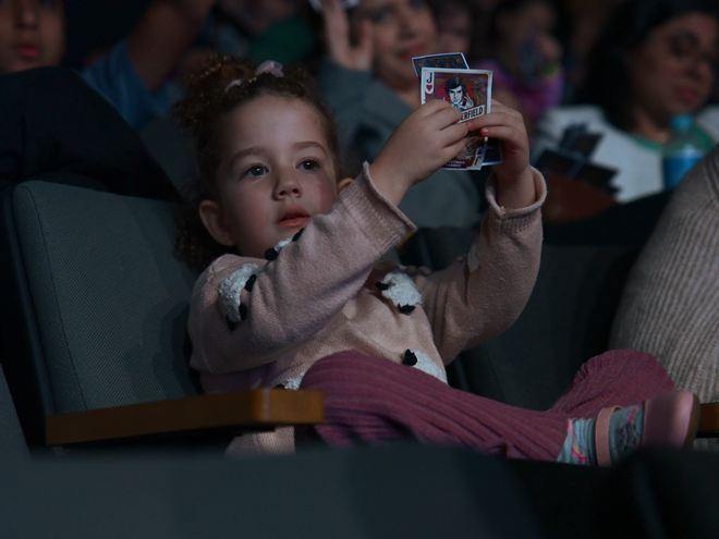 Una ni&ntilde;a levantando su carta durante un n&uacute;mero de magia